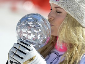 US skier Lindsey Vonn kisses the crystal globe trophy as she celebrates after winning after winning the FIS Alpine Ski World Cup Women's Super G in Meribel on March 19, 2015. (AFP PHOTO / JEFF PACHOUD)