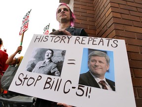David Burnett holds a sign during a C51 protest at Canada Place in Edmonton, Alta. on Saturday,March 14, 2015. Hundreds of people gather to protest the bill. Perry Mah/Edmonton Sun/QMI Agency