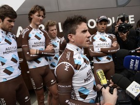 France's Samuel Dumoulin reads a statement to journalists, flanked by teammates of the France's AG2R La Mondiale cycling team, following the doping scandal concerning French rider Lloyd Mondory of the AG2R La Mondiale team. (AFP PHOTO/LIONEL BONAVENTURE)