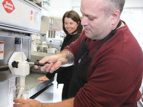 Barrie Yonge Street Dairy Queen owner Laurie Vanommen, left, cheers on Greg McGinnis who has Parkinson's disease, as  he creates the first milkshake in his Show Us Your Shake Facebook challenge to raise money and awareness for Parkinson's. 
CHERYL BROWNE /BARRIE EXAMINER