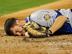 Josh Thole of the New York Mets lays in the dirt with after a collision at home plate with Ty Wigginton (not pictured) of the Philadelphia Phillies at Citizens Bank Park on May 7, 2012. (Drew Hallowell/Getty Images/AFP)