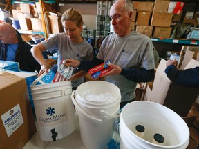 Laurel Kozik, of GlobalMedic, (L) and Tom Carnwell, a retired firefighter and volunteer, pack 500 medical, hygiene and water purification kits destined for Vanuatu Thursday March 19, 2015. (Jack Boland/Toronto Sun)