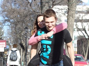 Marko Pujic gives his girlfriend Daniele Sing a piggyback ride down a wet sidewalk on Corydon Avenue in this March 10, 2012 file photo.