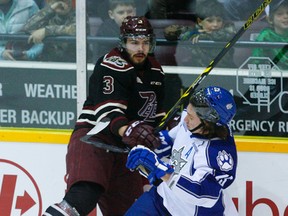 Sudbury Wolves forward Chad Heffernan takes Peterborough Petes defenceman and Sudbury native Cameron Lizzotte into the boards during OHL action in Peterborough on Thursday night.