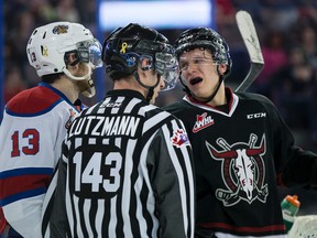 Brandon Baddock and Red Deer defenceman Nelson Nogier engage in conversation under the watchful eye of linesman Jory Lutzmann during a game between the Edmonton Oil Kings and the Red Deer Rebels at Rexall Place on Feb. 25. The Kings and Rebels have their traditional season-closing home-and-home series this weekend.