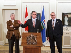 Premier Jim Prentice (centre) speaks beside President of Treasury Board and Minister of Finance Robin Campbell (left) and Minister of Jobs, Skills, Training and Labour minister Ric McIver at a press conference after a meeting between Prentice and union leaders at Government House in Edmonton, Alta., on Thursday, March 19, 2015. Ian Kucerak/Edmonton Sun/QMI Agency