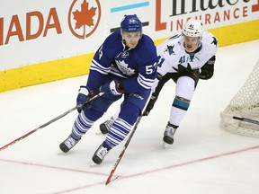 Toronto Maple Leafs centre Sam Carrick (53) skates around the net with the puck as San Jose Sharks defenceman Mirco Mueller (41) applies pressure at Air Canada Centre on March 19, 2015. (TOM SZCZERBOWSKI/USA TODAY Sports)
