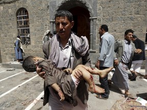 A man carries the body of a child out of the mosque which was attacked by a suicide bomber in Sanaa March 20, 2015. At least 16 people were killed when suicide bombers blew themselves up in two mosques in the Yemeni capital Sanaa on Friday during noon prayers, medical sources told Reuters. The mosques are known to be used mainly by supporters of the Shi'ite Muslim Houthi group which has seized control of the government.  REUTERS/Khaled Abdullah