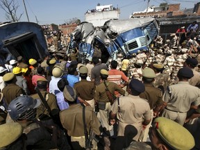 Indian security personnel and rescuers clear the debris of a passenger train after it derailed at Rae Bareli district in the northern Indian state of Uttar Pradesh March 20, 2015. At least 30 people were killed and 50 injured when an express train overshot a railway signal and some carriages went off the rails in a northern Indian state on Friday, officials said. REUTERS/Stringer