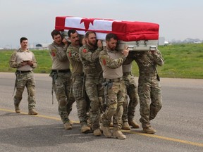 Pallbearers from the Canadian Special Operations Regiment (CSOR) carry the casket of Sergeant Andrew Joseph Doiron, during the aircraft ramp ceremony at Erbil International Airport, in Iraq in this March 8, 2015 handout photograph. A Canadian soldier was killed on March 6 in a friendly fire incident in Iraq, Canada's defense department said on Saturday, in the first fatality for the country during its current military mission there. Three other Canadian soldiers were injured. Picture taken March 8, 2015. REUTERS/Canadian Armed Forces/Handout via Reuters