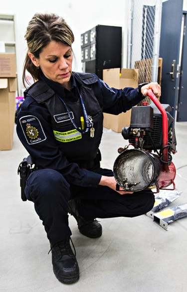 Border services officer Jennifer Kennedy shows off an air compressor that was stuffed with illegal steroids at the Canada Border Services Agency office at the Edmonton International Airport in Leduc, Alta., on Thursday, March 5, 2015. Codie McLachlan/Edmonton Sun/QMI Agency