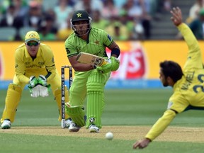 Australia’s spin bowler Glenn Maxwell (right) dives to stop a shot by Pakistan’s batsman Umar Akmal (centre) at the Cricket World Cup quarterfinal in Adelaide, Australia. Australia won by six wickets, with 97 balls remaining. (AFP)