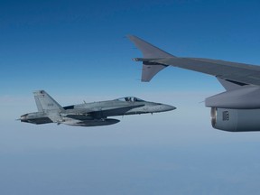A CF-18 Hornet fighter jet keeps pace with the CC-150 Polaris after refuelling for the next mission over Iraq during Operation IMPACT on February 4, 2015.  (OP Impact, DND photo)