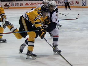 Sarnia Sting forward Alexandre Renaud battles to get around Windsor Spitfires defenceman Jalen Chatfield during the Ontario Hockey League game at RBC Centre Friday night. The Sting won 7-2. (Terry Bridge, The Observer)