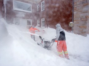 Workers remove snow from an apartment complex during another winter storm in Halifax, N.S.
Scott Blackburn/QMI Agency