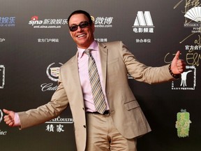 Actor Jean-Claude Van Damme poses for photographs on the red carpet during the closing ceremony of the 17th Shanghai International Film Festival in Shanghai, June 22, 2014. REUTERS/Stringer