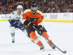 Jan 15, 2015; Philadelphia, PA, USA; Philadelphia Flyers defenseman Nick Schultz (55) skates with the puck as Vancouver Canucks left wing Daniel Sedin (22) chases during the second period at Wells Fargo Center. Mandatory Credit: Bill Streicher-USA TODAY Sports