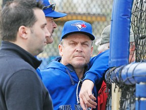 Blue Jays manager John Gibbons, chatting with GM Alex Anthopoulos, admits there are a lot of roster decisions still waiting to be made. (STAN BEHAL, Toronto Sun)