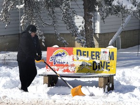 A man shovels snow away from a bus stop on 106 st and 70 ave in Edmonton, Alberta on Sunday March 22, 2015. Perry Mah/Edmonton Sun/QMI Agency