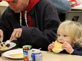 Easton McKinlay, nearly two years old, munches on a pancake next to his dad, David, at the Alvinston Maple Syrup Festival Sunday. The 43rd annual festival included the local fireman's association-hosted pancake breakfast at the Alvinston Community Centre, and maple syrup-making demonstrations in the A. W. Campbell Conservation Area. TYLER KULA/ THE OBSERVER/ QMI AGENCY