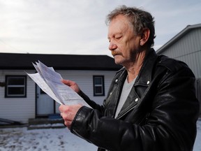 Gary Lowe holds his Hydro One bills outside his home in Bayside east of Trenton, Ont. Wednesday, January 21, 2015. His billing concerns with the electrical utility took nearly two years to resolve and required the intervention of staff of the Ontario ombudsman's office.