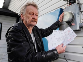 Gary Lowe holds his Hydro One bills outside his home in Bayside east of Trenton, Ont. Wednesday, January 21, 2015. Though Hydro One and an inspector with the office of Ontario's ombudsman say his nearly two-year customer-service battle has been resolved, Lowe said he may yet ask Measurement Canada to test his meter's accuracy.