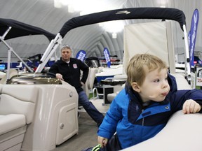 Connor Stark, foreground, with grandfather Bill Trenhaile, explores the world of pontoon boats at the Kingston Home, Cottage and Boat Show on Sunday. (Steph Crosier, The Whig-Standard, QMI Agency)