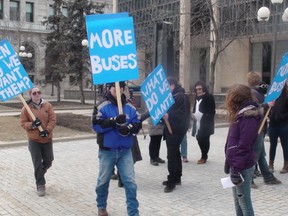 About a dozen people rallied in front of City Hall Sunday, March 22, 2015, to demand more bus service.