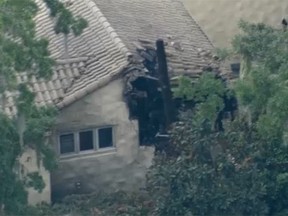 Aerial photos showed damage to a house in Orlando, Florida, that was the site of a helicopter crash.(WFLA screengrab)