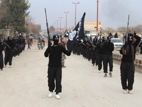 Fighters of al-Qaida linked Islamic State of Iraq and the Levant carry their weapons during a parade at the Syrian town of Tel Abyad, near the border with Turkey January 2, 2014. (REUTERS/Yaser Al-Khodor)