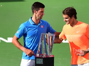 Novak Djokovic (L) of Serbia and Roger Federer (R) of Switzerland greet each other during the trophy presentation following the men's final of the BNP Paribas Tennis Open in Indian Wells, California on March 22, 2015.  Djokovic defeated Federer 6-3, 6-7 (5), 6-2. (AFP PHOTO / FREDERIC J. BROWN)