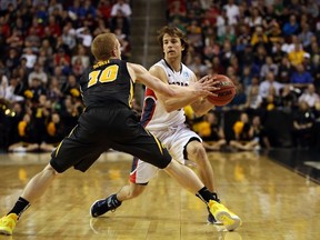 Canadian Chris Pangos of Gonzaga tries to get past Iowa's Mike Gessell during their NCAA game last night. Pangos hit four threes to help second-seeded Gonzaga to its win. (AFP)