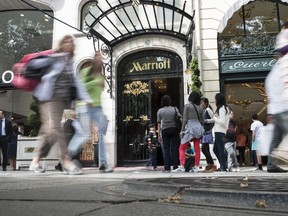 People walk in front of the entrance of the five-star Paris Marriott Hotel Champs-Elysees, on June 17, 2014 in Paris. AFP PHOTO / FRED DUFOUR