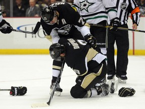 Pittsburgh Penguins right winger Pascal Dupuis is helped by teammate Evgeni Malkin after being injured during the second period of an NHL game against the Dallas Stars at Consol Energy Center on Oct. 16, 2014. (Don Wright/USA TODAY Sports)