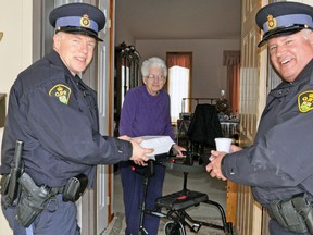 Constables Kees Wijnands (left) and Glen Childerley of the Perth County OPP deliver a hot and nutritious meal to Elizabeth Vink on Monday, March 16. The officers were helping out with the Meals On Wheels program in Mitchell. Every March, the Meals On Wheels program is highlighted in communities across North America thanks to the March For Meals campaign. KRISTINE JEAN/MITCHELL ADVOCATE