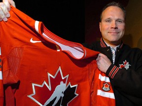 Dave Lowry holds up a Team Canada hockey sweater. (QMI Agency)