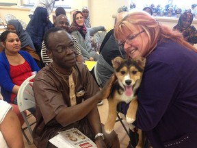 Animal Services adoption and community education co-ordinator, Lorna Verschoore, introduces a dog from the shelter to new immigrants earlier this month. (SUBMITTED PHOTO)