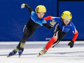 Matthew Freitag of Ottawa, left, keeps a slight lead on Seamus Keiley of Kingston as they round a corner during the second of three laps in their Boys 9 race at the Ontario Speed Skating Association's Provincial C Championships at the Western Fair Sports Centre in London on Sunday. Keiley went on to win the race. (Craig Glover/QMI Agency)