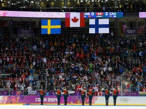 Flags of gold medalists Canada, silver medalists Sweden and bronze medalists Finland are raised during the victory ceremony for the men's ice hockey competition during the Sochi 2014 Winter Olympic Games, February 23, 2014. (REUTERS/Laszlo Balogh)