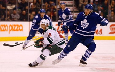 Toronto Maple Leafs David Booth (20) bails from a check by Minnesota Wild's Jared Spurgeon (46) in Toronto on Monday March 23, 2015. Jack Boland/Toronto Sun/QMI Agency