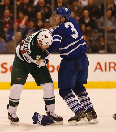 Toronto Maple Leafs� Dion Phaneuf (3) D tussles with Minnesota Wilds� Kyle Brodziak (21) C during the second period in Toronto on Monday March 23, 2015. Jack Boland/Toronto Sun/QMI Agency