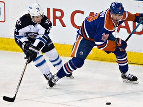 Ben Scrivens stops Jets Adam Lowry as he's checked by Oscar Klefbom during first-period action monday at Rexall Place. (Codie McLachlan, Edmonton Sun)