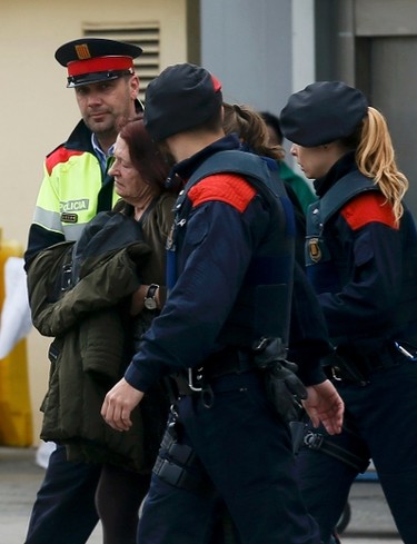 Spanish police officers escort family members of those killed in Germanwings plane crash as they arrive at Barcelona's El Prat airport on March 24, 2015. (REUTERS/Albert Gea)