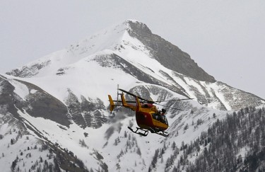 A rescue helicopter from the French Securite Civile flies over the French Alps during a rescue operation near the crash site of an Airbus A320, near Seyne-les-Alpes, March 24, 2015. (REUTERS/Jean-Paul Pelissier)
