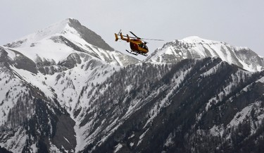 A rescue helicopter from the French Securite Civile flies over the French Alps during a rescue operation after the crash of an Airbus A320, near Seyne-les-Alpes, March 24, 2015. (REUTERS/Jean-Paul Pelissier)