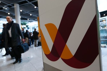 A passenger walks past a Germanwings compnay logo at Dusseldorf airport on March 24, 2015. (REUTERS/Ina Fassbender)