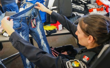 York Regional Police show over a million dollars in clothing that was shoplifted from major brand stores in the Toronto and York Region area. Five people were arrested. Pc. Laura Nicolle holds up a pair of $450.00 Jeans on Tuesday March 24, 2015. Dave Thomas/Toronto Sun