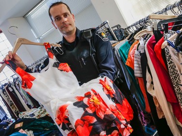 York Regional Police show over a million dollars in clothing that was shoplifted from major brand stores in the Toronto and York Region area. Five people were arrested. Pc. Andy Pattenden, holds up one of hundreds of high end dresses on Tuesday March 24, 2015. Dave Thomas/Toronto Sun