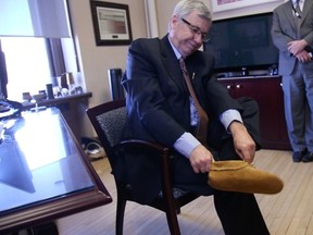 Finance Minister Robin Campbell put on a pair of moccasins march 24, 2015, and said the province is "looking long-term" in the Thursday budget. (EDMONTON SUN)