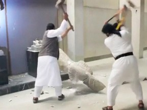 Men use sledgehammers on a toppled statue in a museum at a location said to be Mosul in this still image taken from an undated video published by Islamic State on February 26, 2015. Ultra-radical Islamist militants in northern Iraq have destroyed a priceless collection of statues and sculptures from the ancient Assyrian era. (REUTERS)